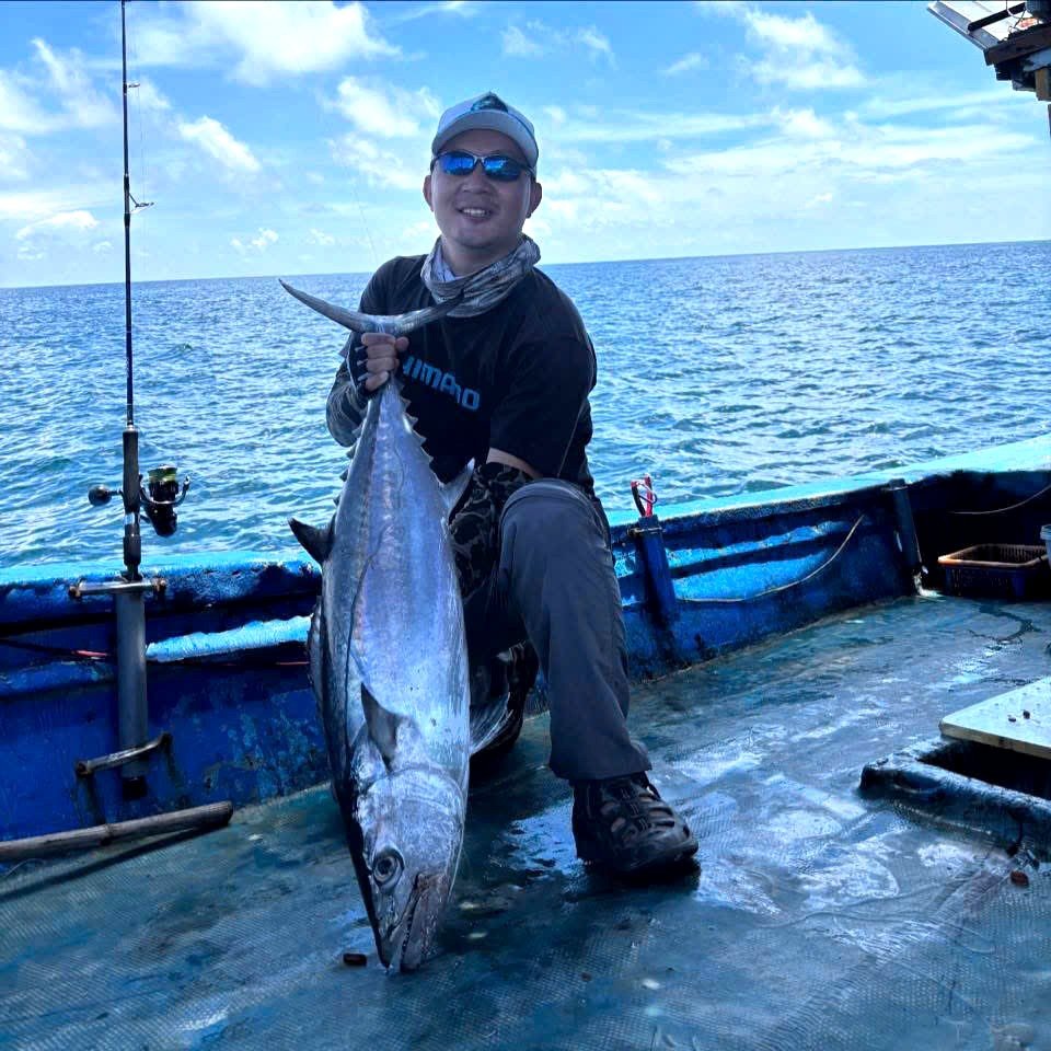 Huy holding a big catch on a fishing boat off Da Nang
